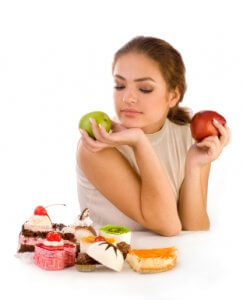 Young beautiful women with apples looking at cookies